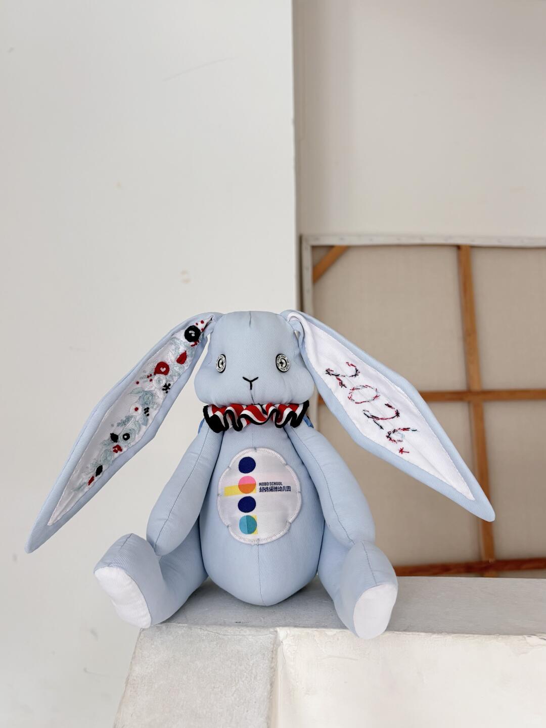 Finished light blue denim bunny plush sitting upright with embroidered ears and a ruffled collar.