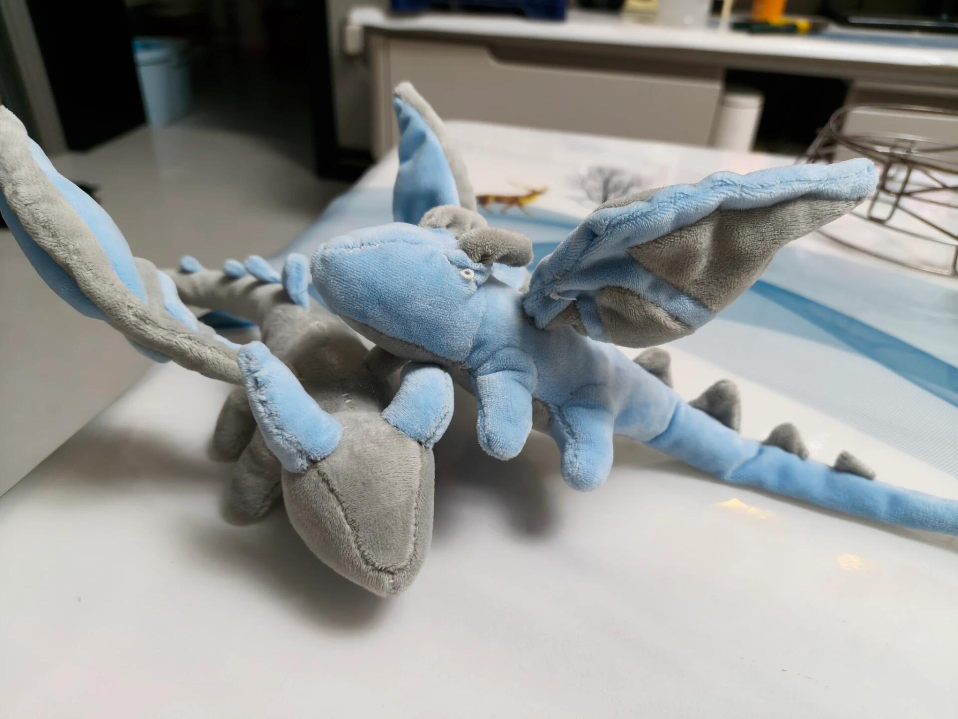 Plush toy resembling a dragon on a table