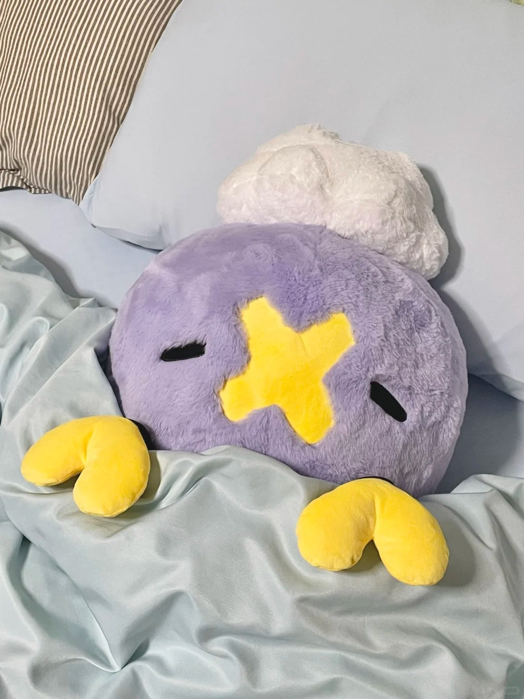Large Drifloon plush cushion resting on a bed with detached yellow heart tips