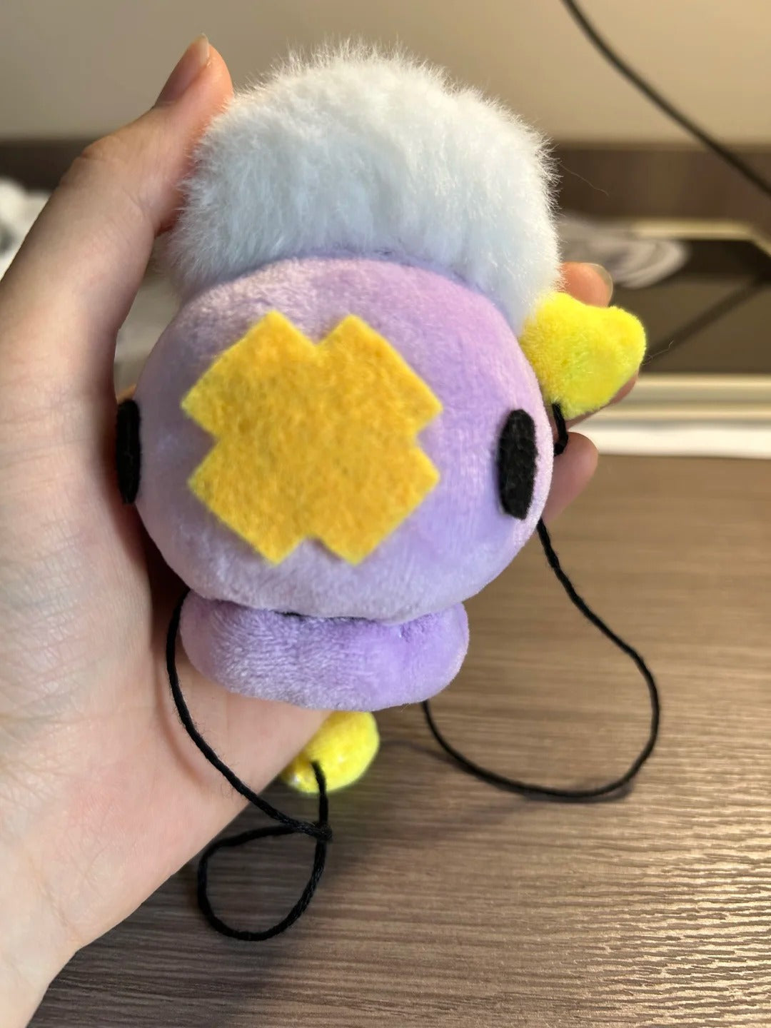 Hand-held lavender Drifloon plush with fluffy cloud and yellow heart detail