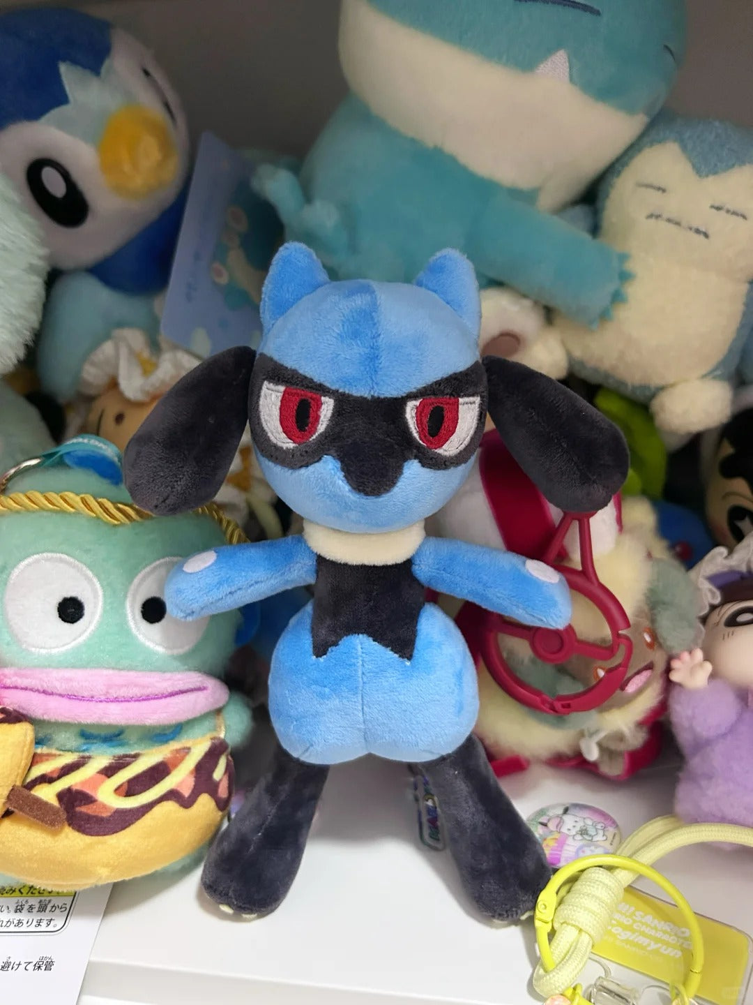 Full front view of the finished Lucario-inspired soft toy with embroidered eyes and contrasting plush fabric details
