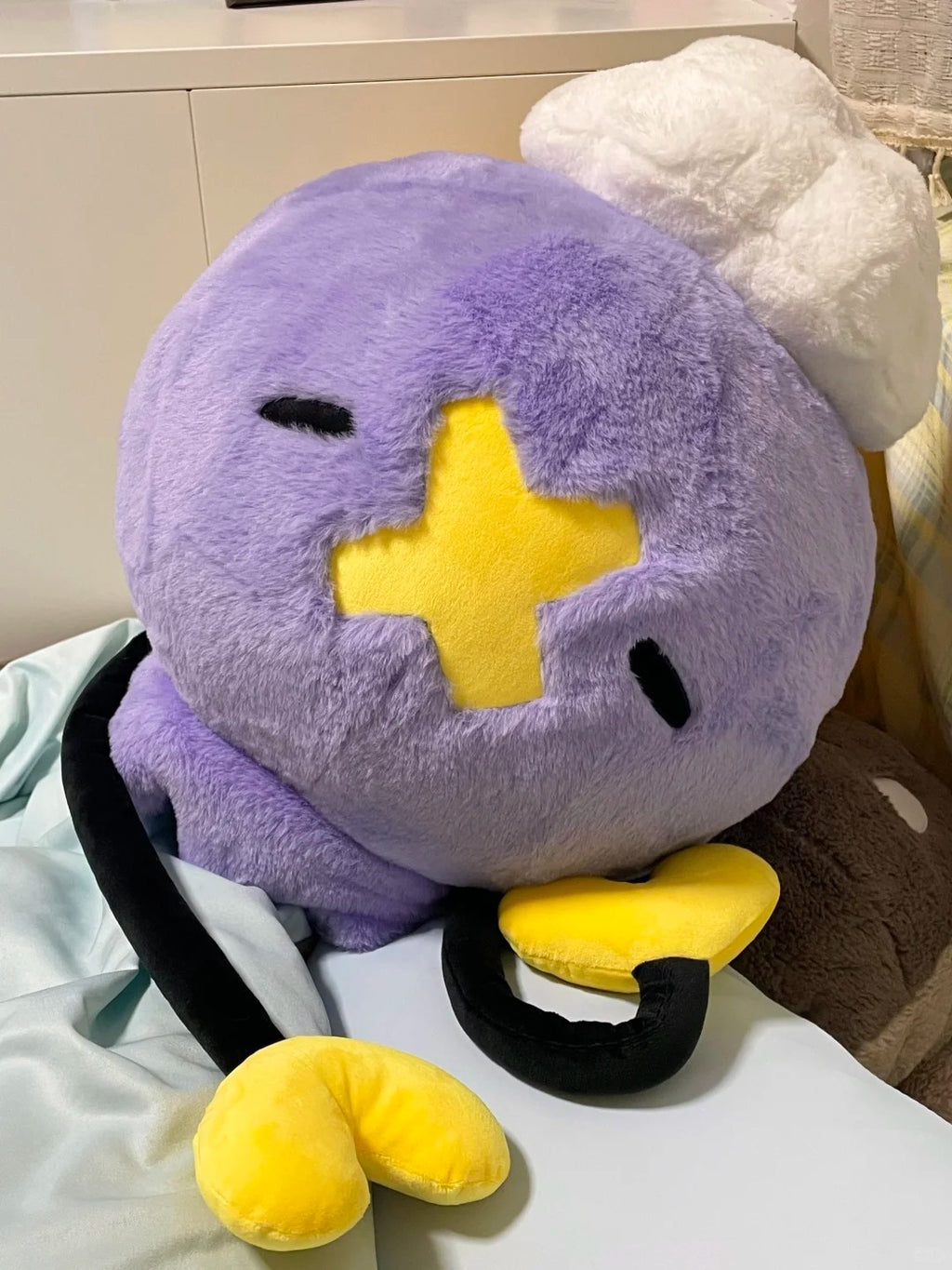 Oversized purple Drifloon plush cushion with white cloud and yellow heart-shaped tips