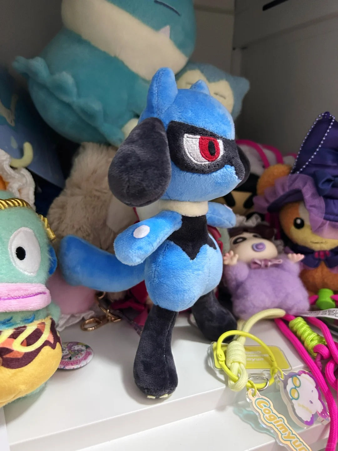 Side view of a handmade Lucario-inspired plush showing its long ears, arm marking, rounded body and tail