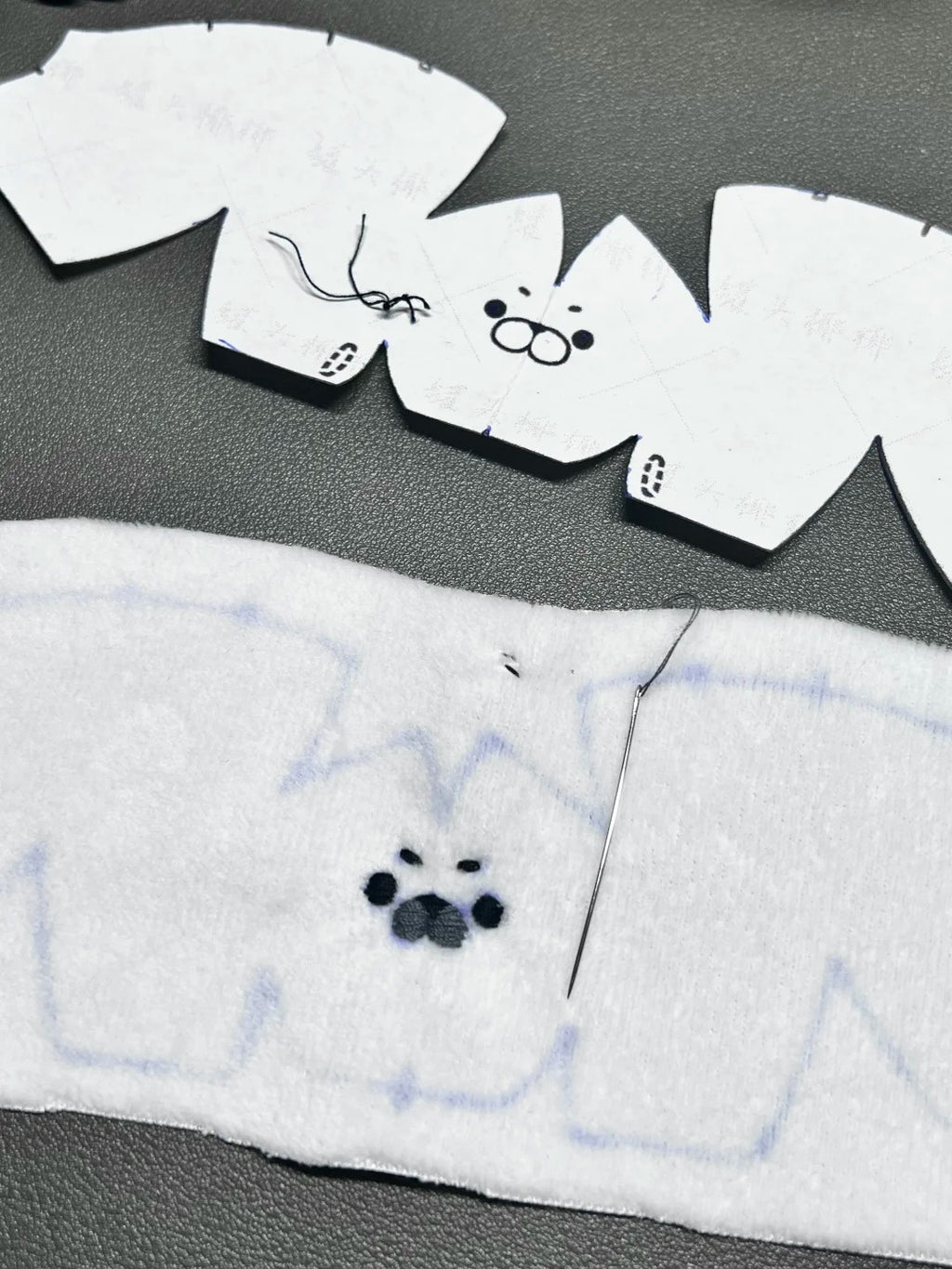Baby Seal Sewing Pattern White fabric with black paw print design on a gray surface