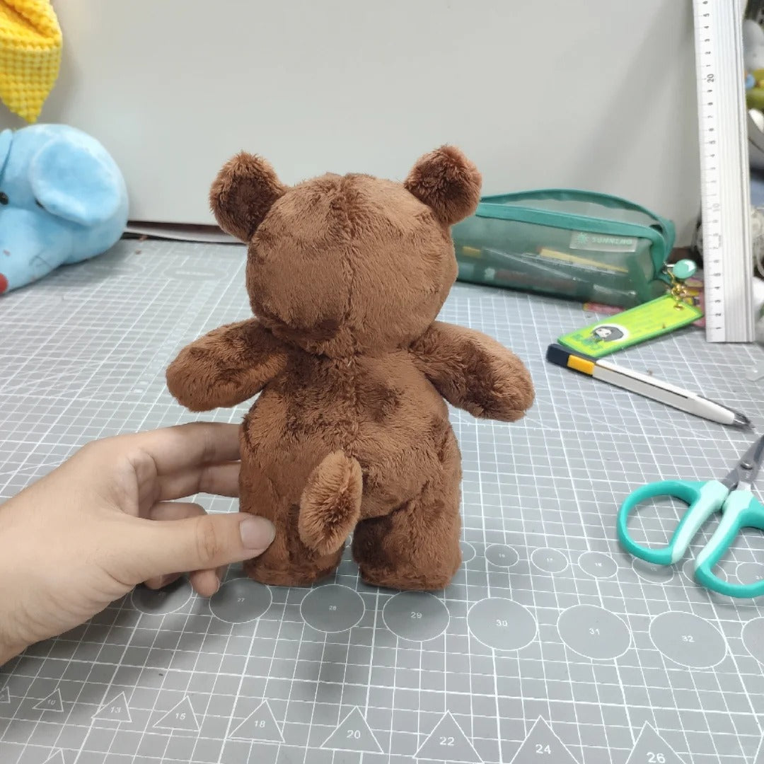 Brown teddy bear on a cutting mat with tools in the background