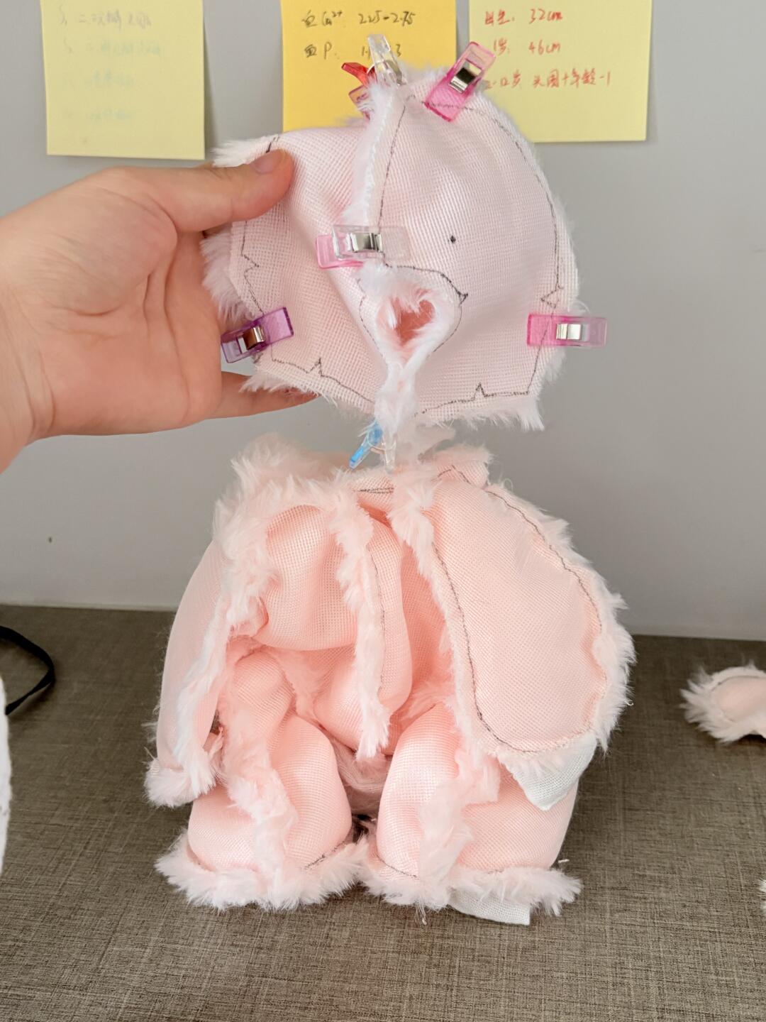 Jellycat Barcelona bear Pink plush toy with white fringes held by a hand against a neutral background