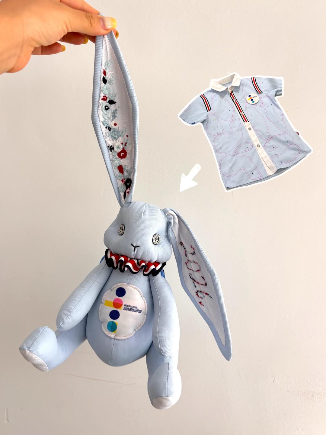 Light blue denim bunny plush held by one ear, with embroidered ears and a ruffled collar; a light blue shirt is shown as the upcycled source fabric.