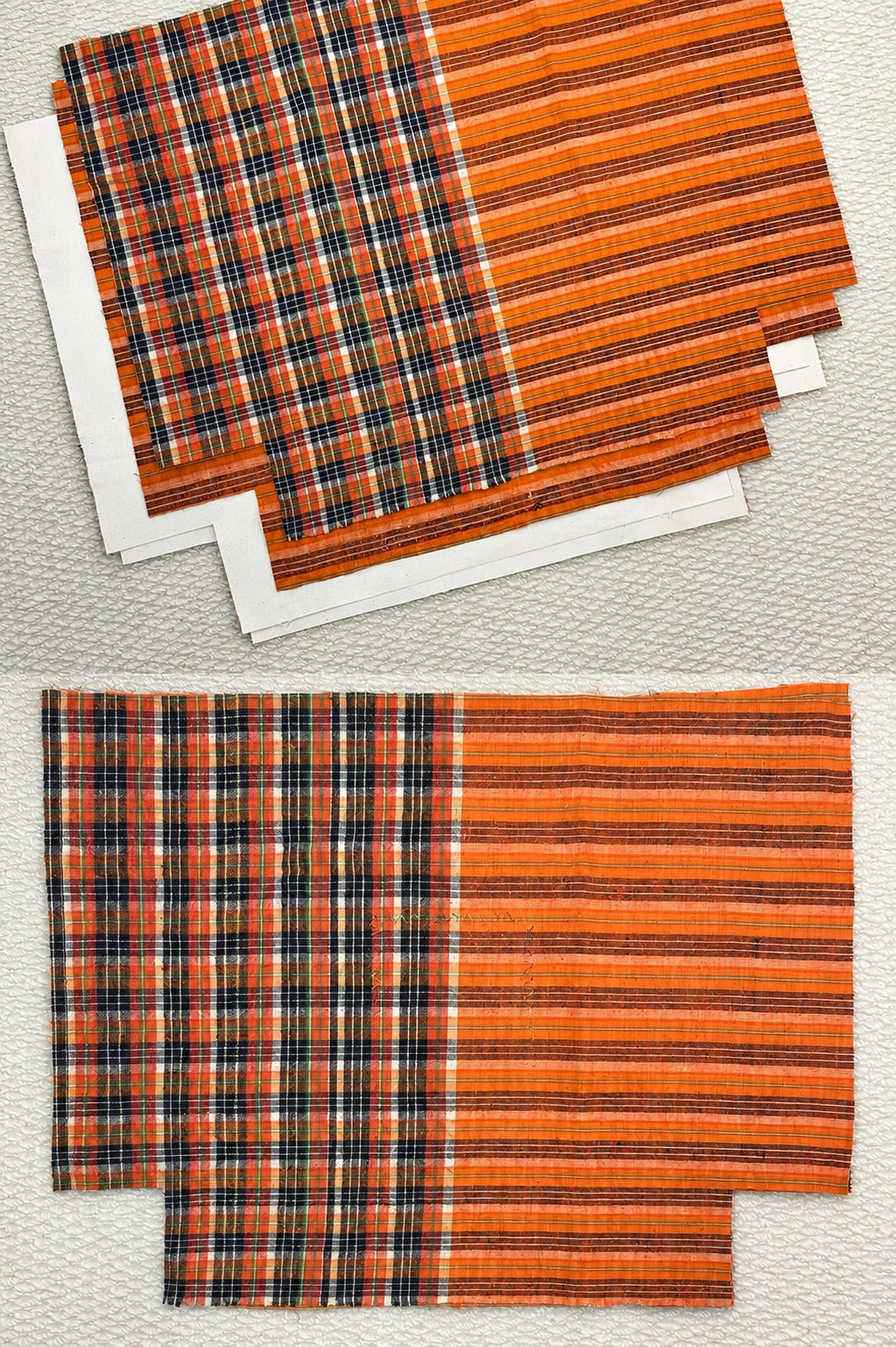 Two rectangular woven placemats with an orange, black, and white striped and plaid design, stacked on a textured light beige surface.