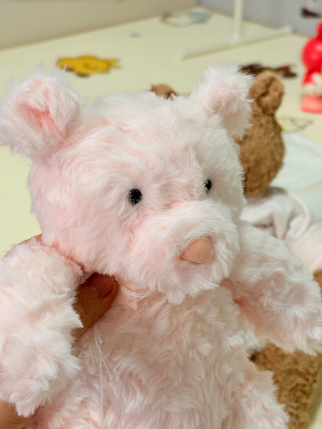Pink plush toy with a heart on a soft surface
