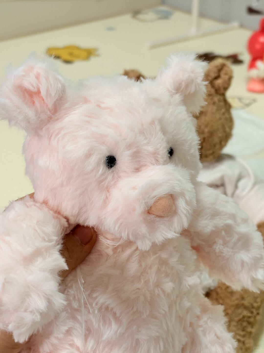 Pink plush toy with a heart on a soft surface