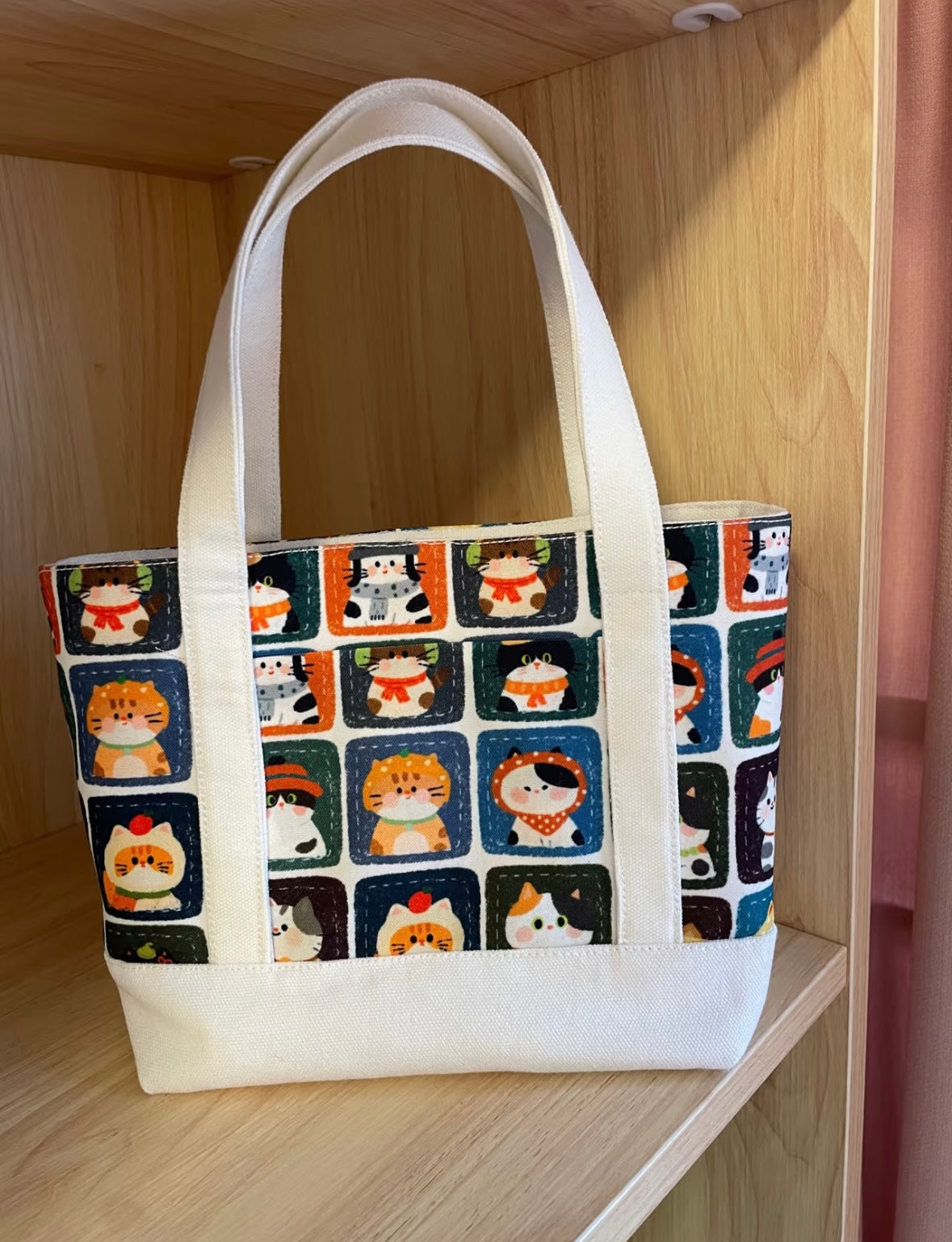 Tote bag with cat pattern on a wooden shelf