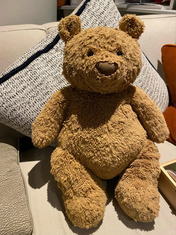 Brown teddy bear sitting on a textured surface