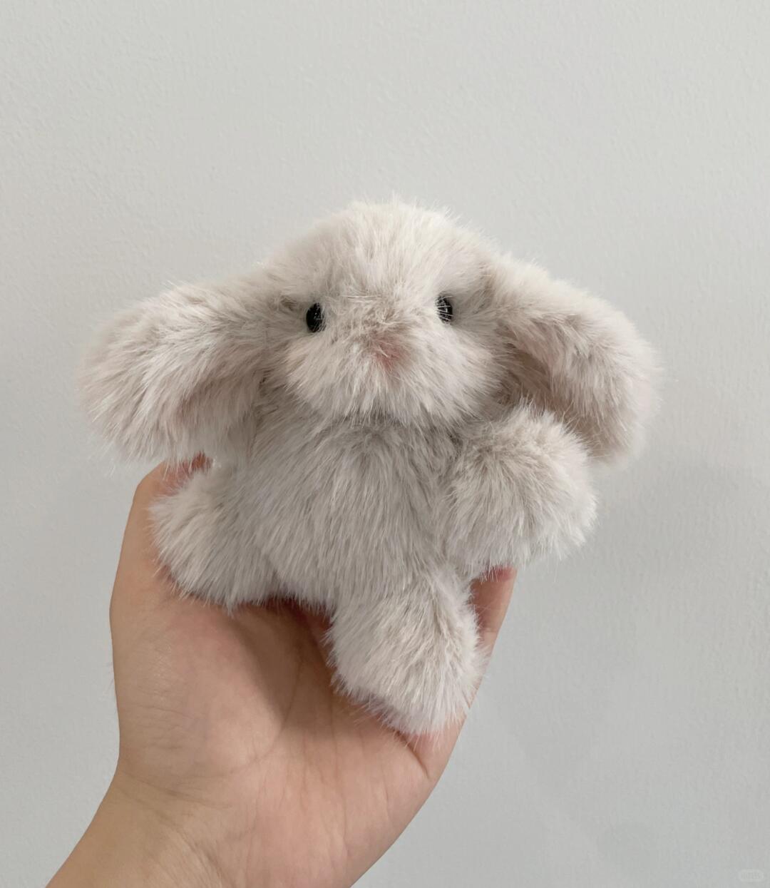 Bunny Plush toy resembling a fluffy creature held in a hand against a plain background
