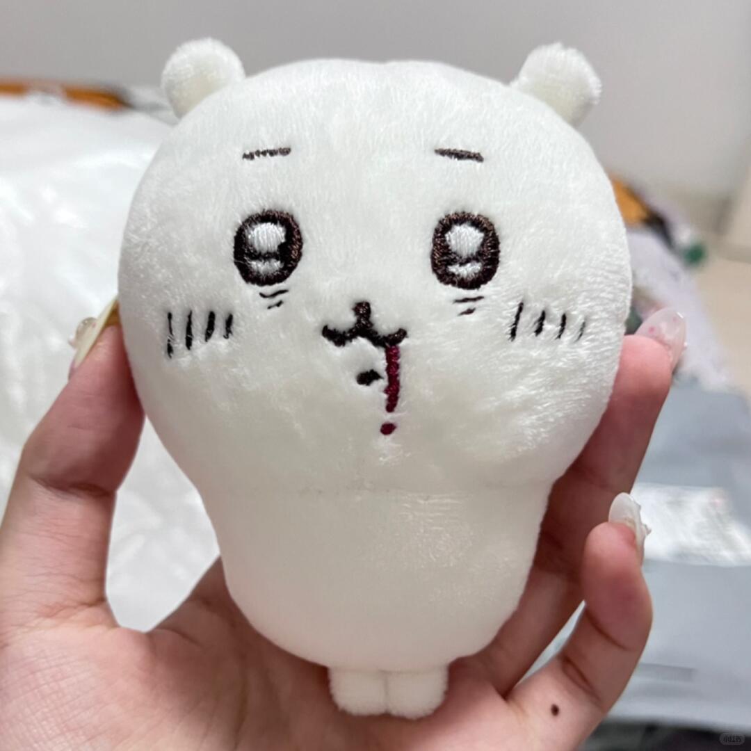 White Chiikawa plush with embroidered face held in one hand