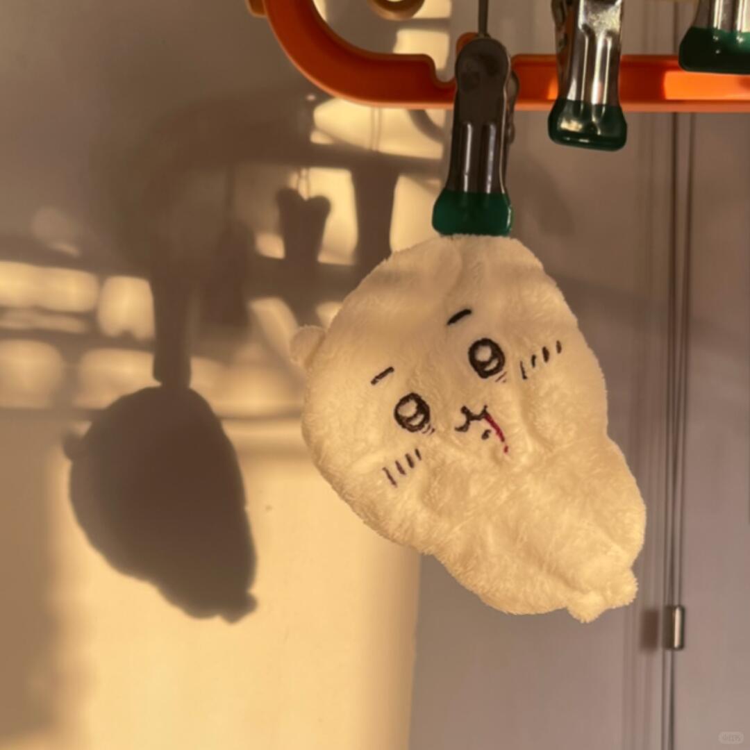 Chiikawa plush bag charm hanging in warm sunlight