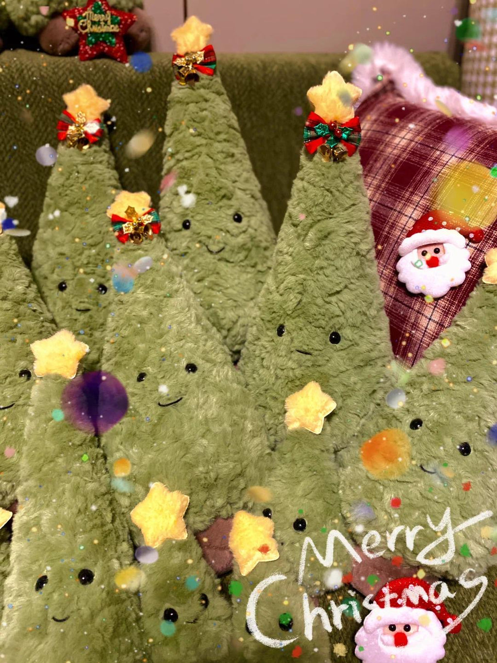 Green plush Christmas trees with festive decorations on a green background.