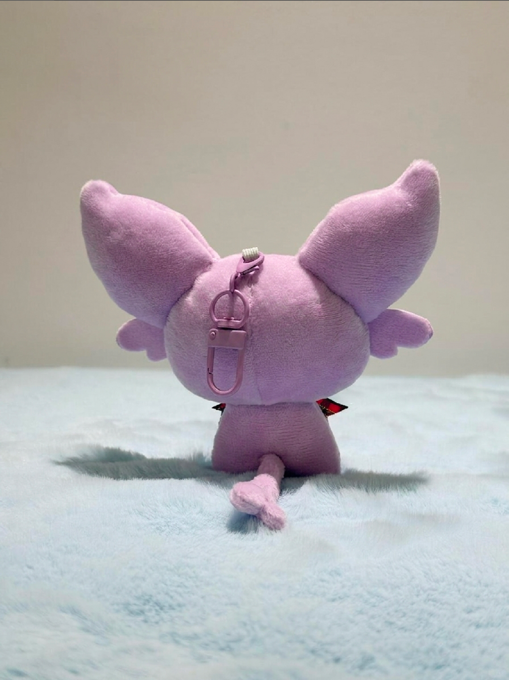 Pink eevee plush toy with large ears on a light blue blanket