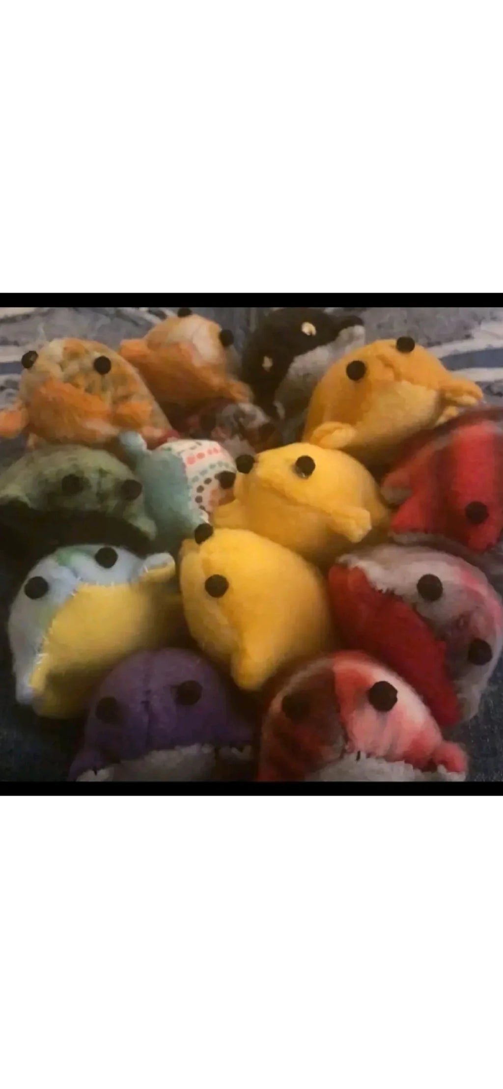 A collection of handmade fabric frogs in yellow, green, blue, pink and patterned fabrics.
