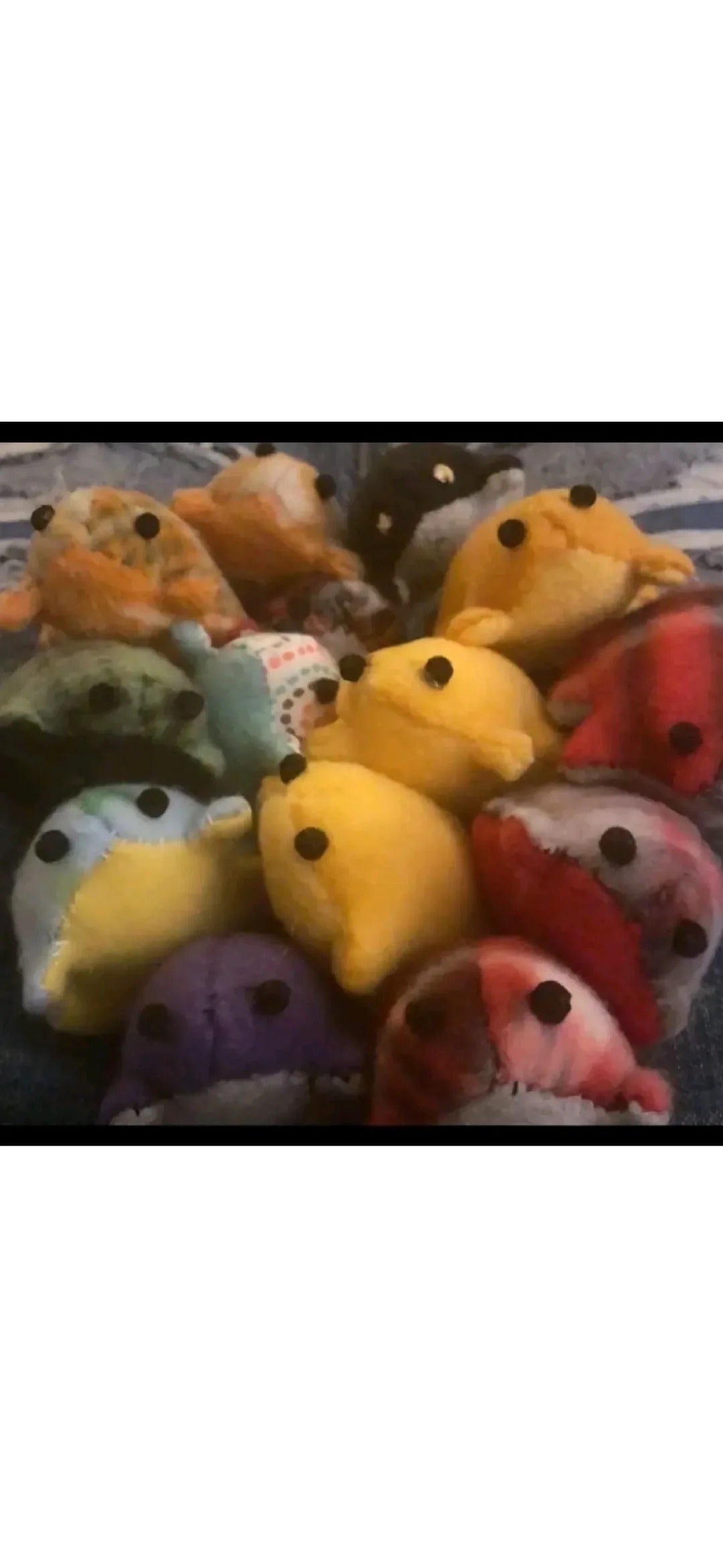 A collection of handmade fabric frogs in yellow, green, blue, pink and patterned fabrics.