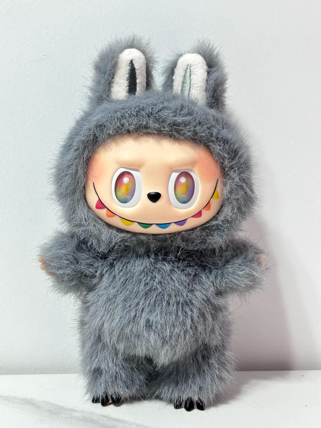 Labubu Plush toy with a fuzzy gray exterior and colorful face on a light background