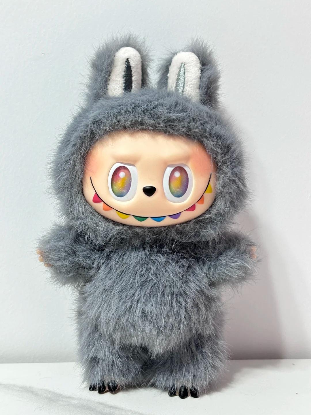 Labubu Plush toy with a fuzzy gray exterior and colorful face on a light background