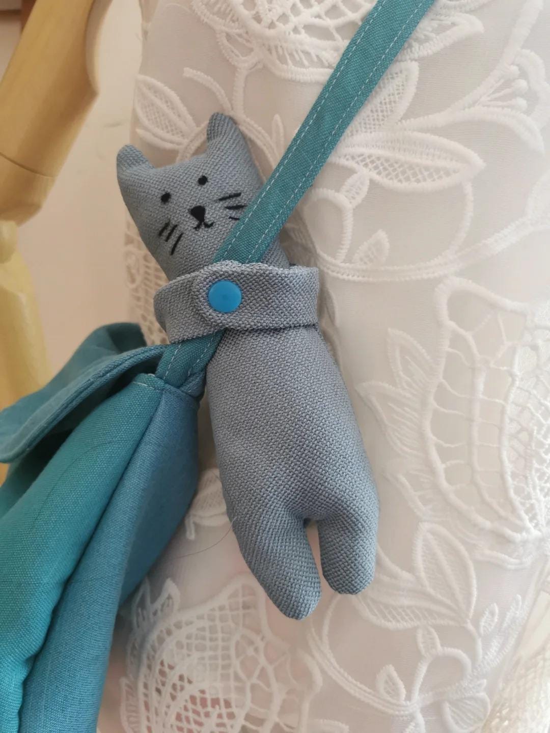A cat-shaped handle plush on a textured white surface