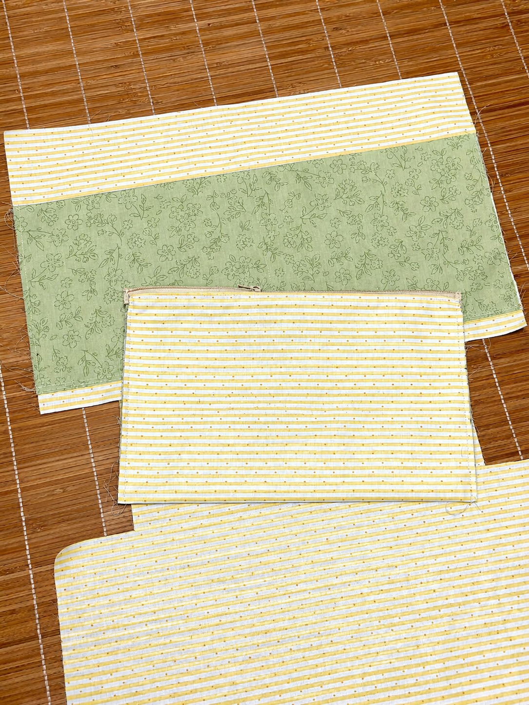 Three rectangular mats with different patterns on a wooden floor.
