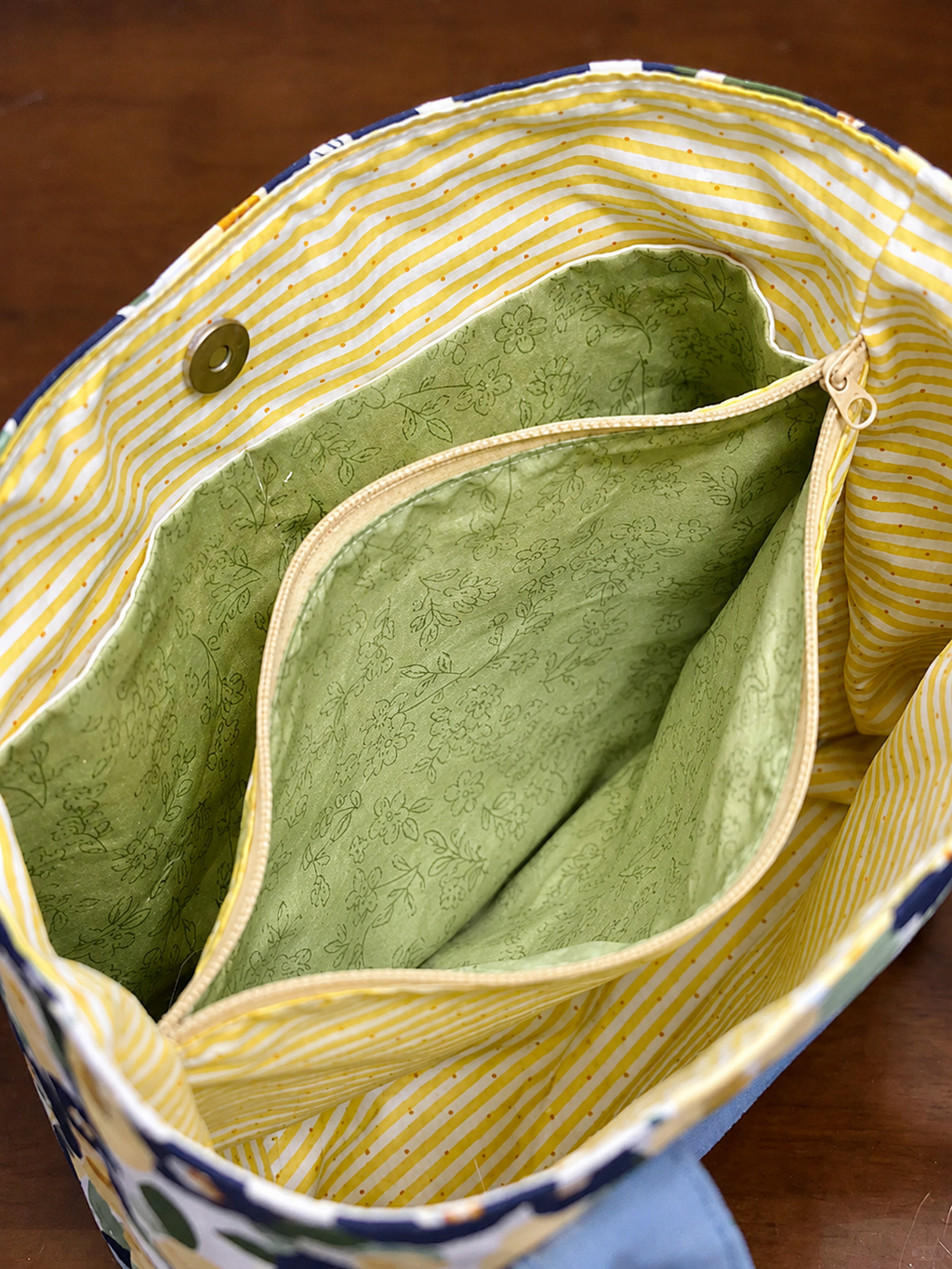 Close-up of a green fabric inside a yellow and blue bag.