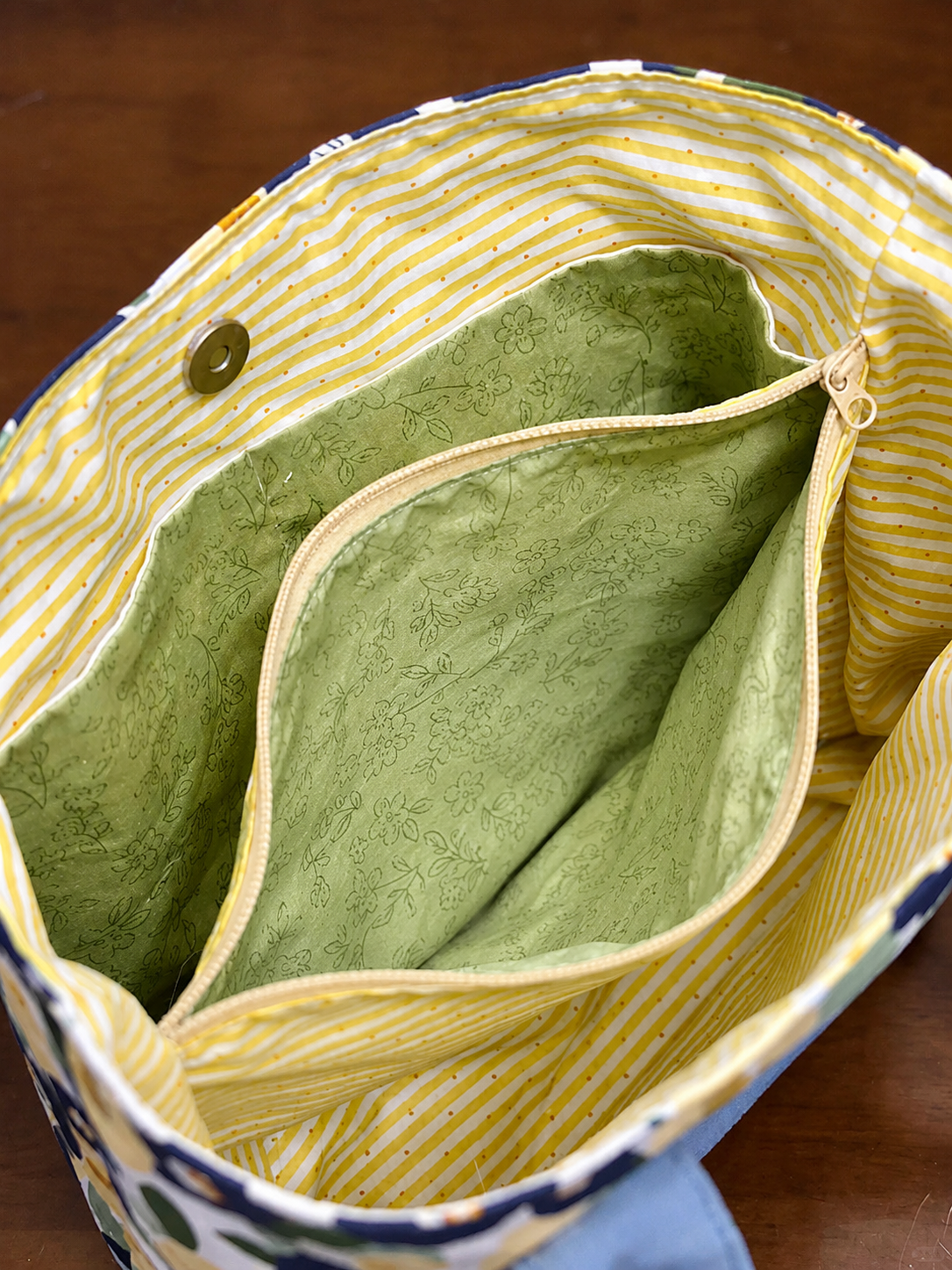 Close-up of a green fabric inside a yellow and blue bag.