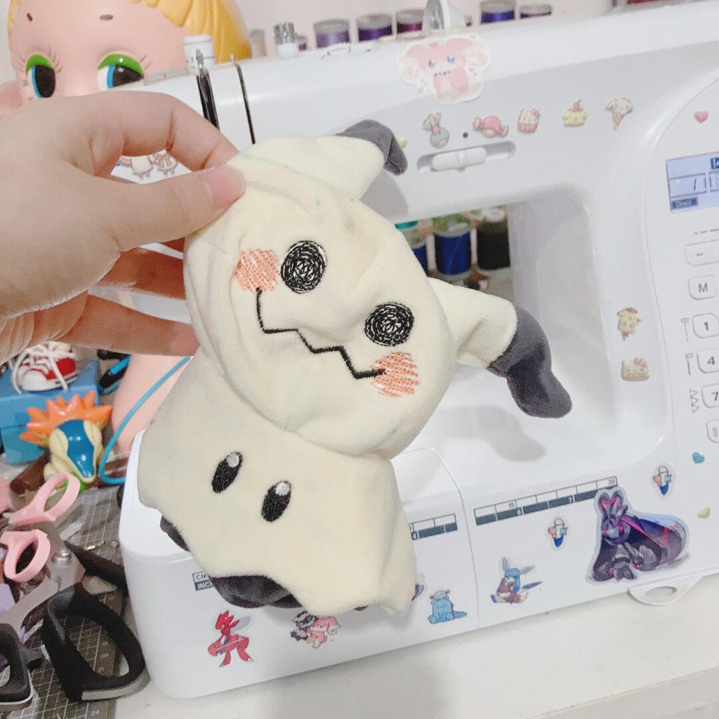 Mimikyu Plush ghost toy held in front of a sewing machine