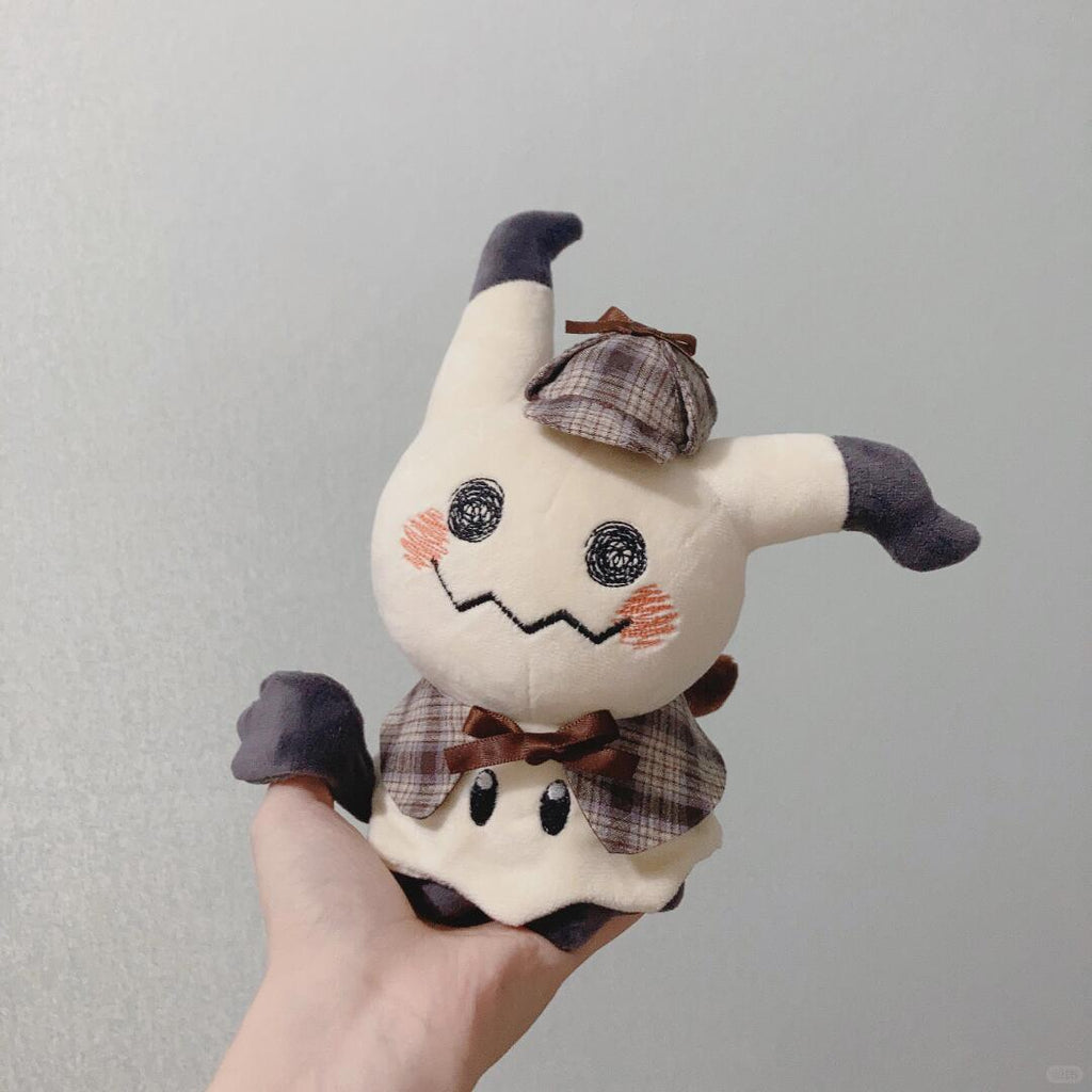 Mimikyu Plush toy resembling a ghost with a hat held by a hand against a plain background