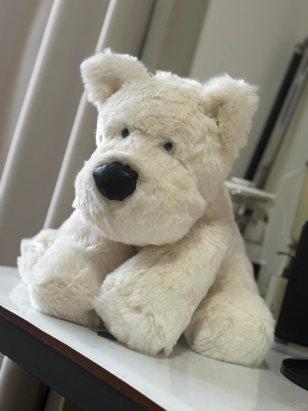 Handmade White scottie dog plushie with a black nose sitting on a surface.
