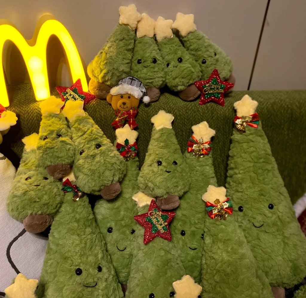 Green plush Christmas trees with decorative elements on a green surface.