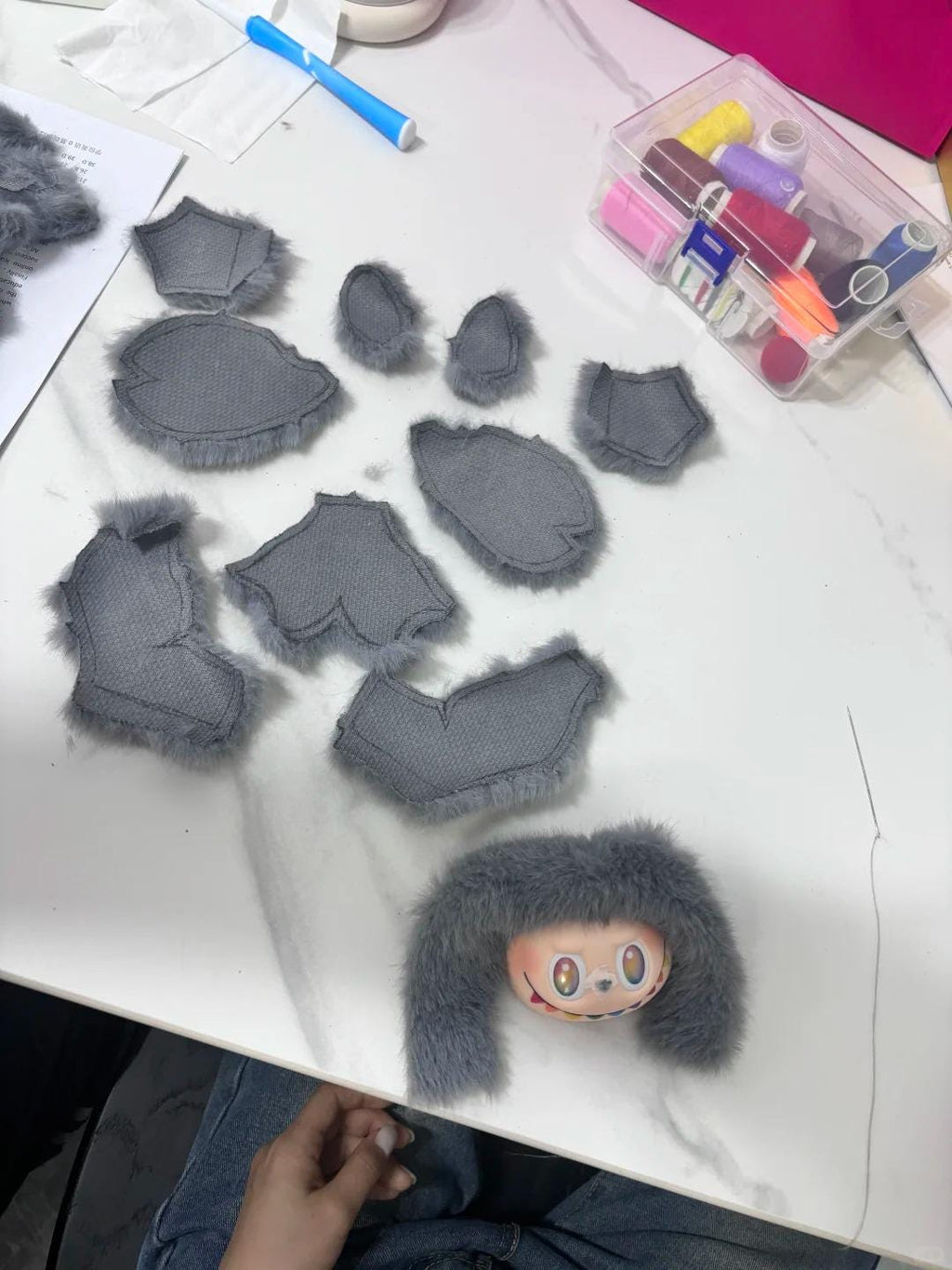 Gray foam pads on a white surface with a small labubu head.