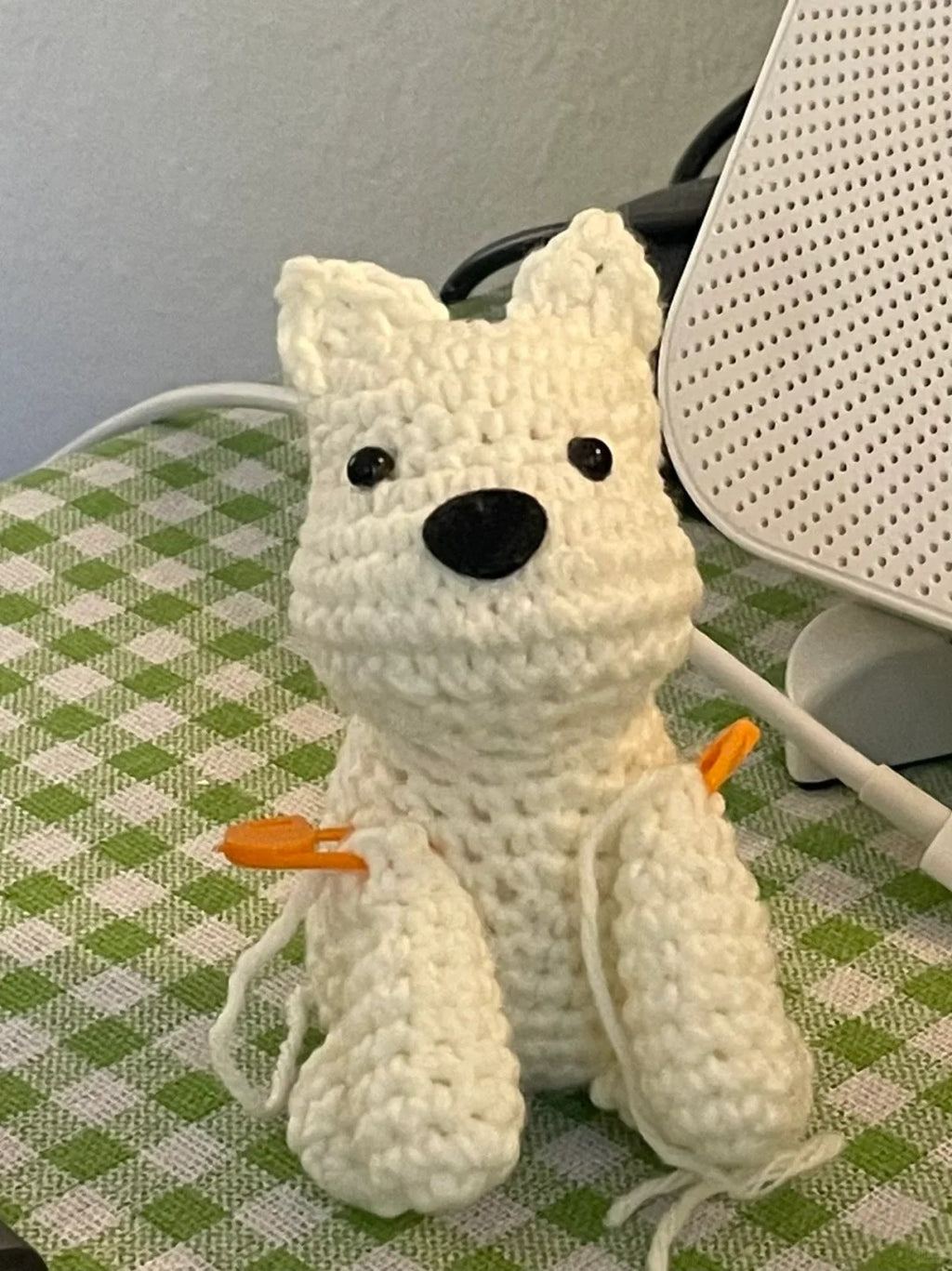 White knitted dog toy on a checkered surface