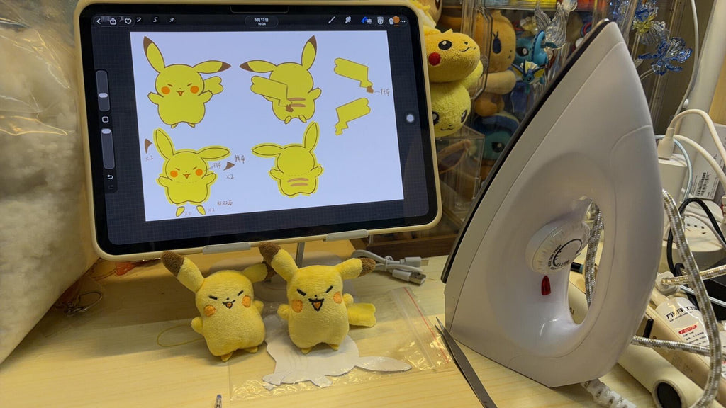 Pikachu sewing pattern: Tablet displaying images of Pikachu next to plush toys and an iron on a table.