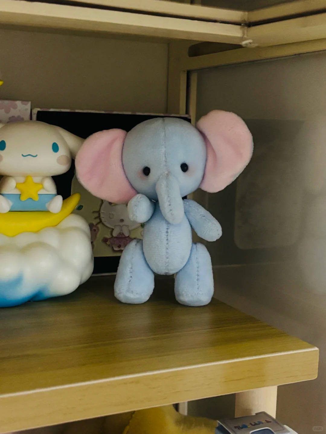 Finished light blue elephant plush with pink ears displayed upright on a shelf