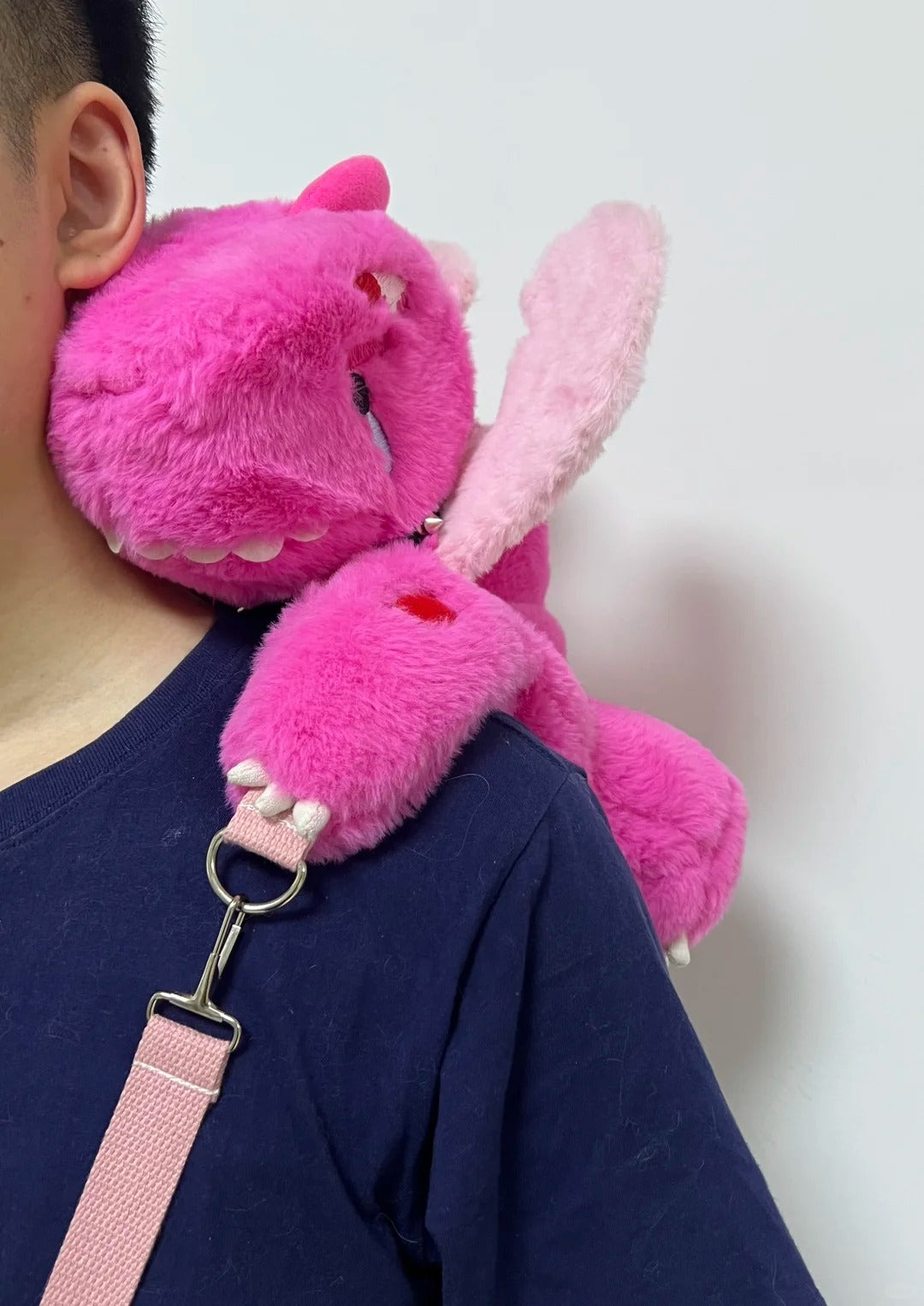 Close-up of the Boltusk dragon plush face, white claws, tusks, and lightning stitching