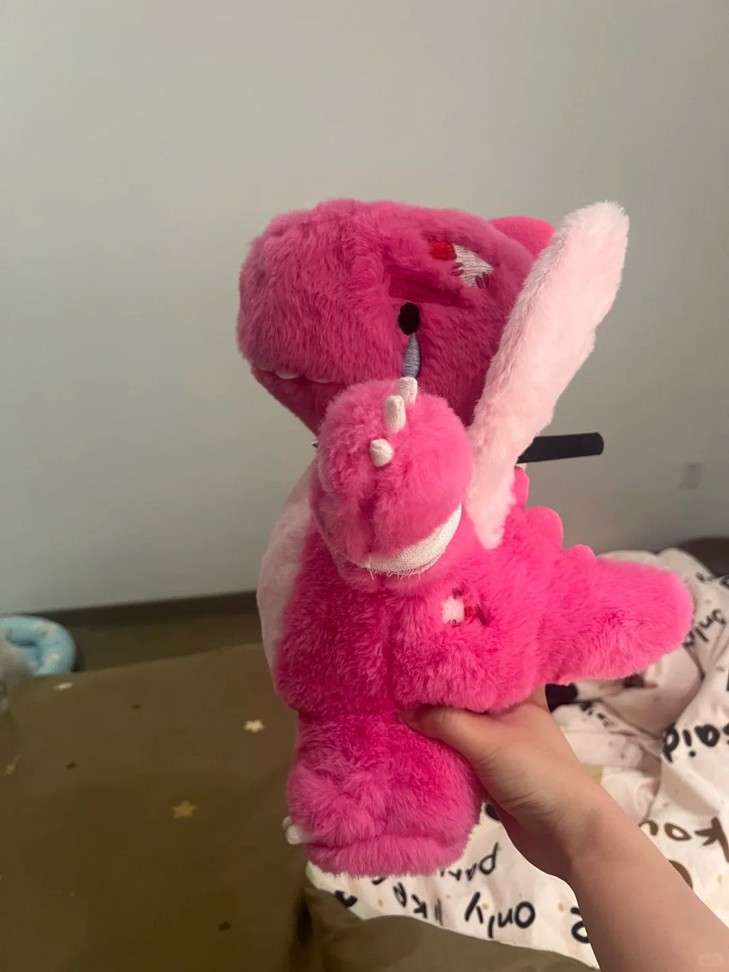 Three-quarter view of a pink Boltusk lightning dragon plush held in one hand