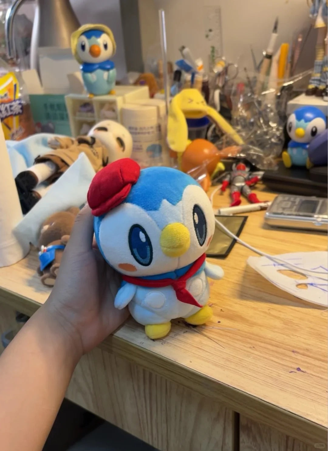 Hand-held café Piplup plush with a red beret and matching scarf