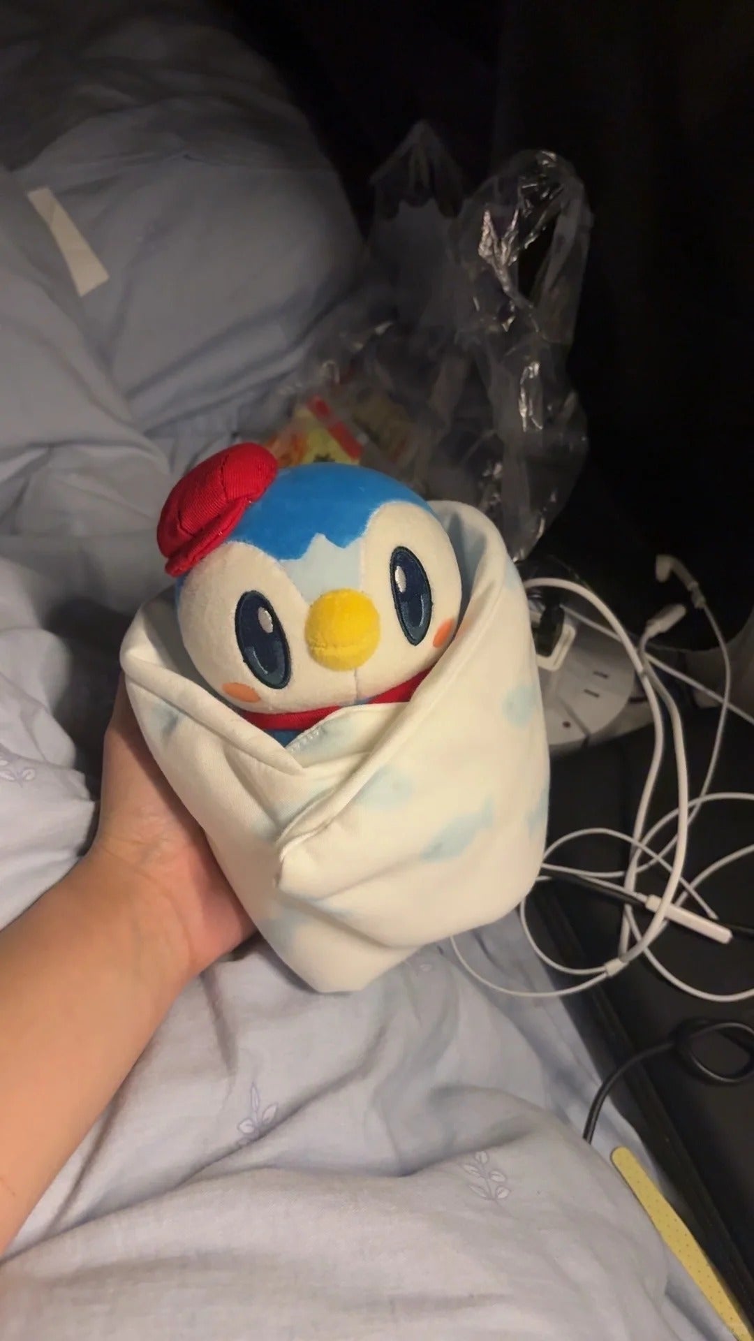 Small café Piplup plush wrapped in fabric with its red beret visible