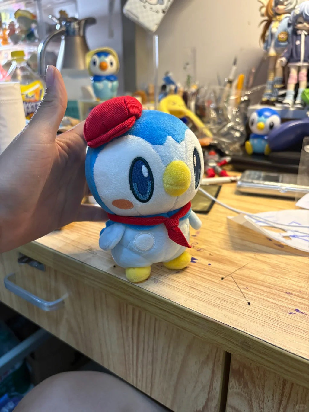 Three-quarter view of a finished café Piplup plush on a sewing desk