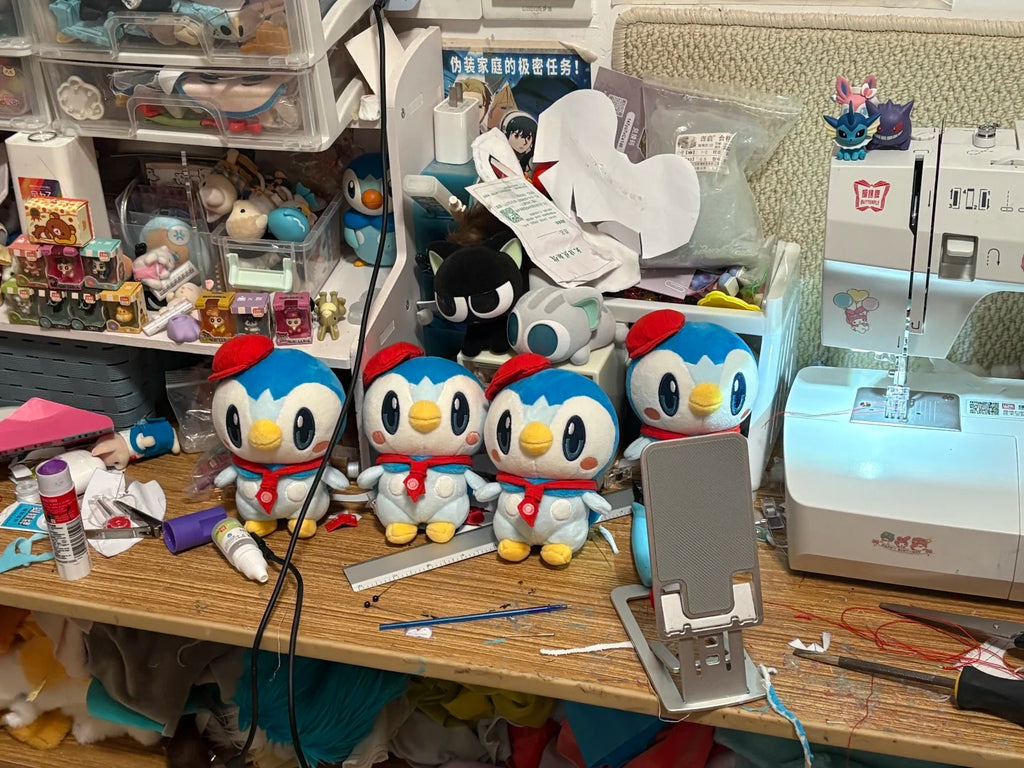 Four café Piplup plush sewing samples displayed beside a sewing machine