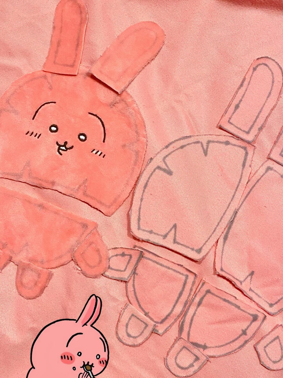 Cut fabric pattern pieces for a pink Chiikawa-inspired full-body plush, including head, ears, body, arms and legs