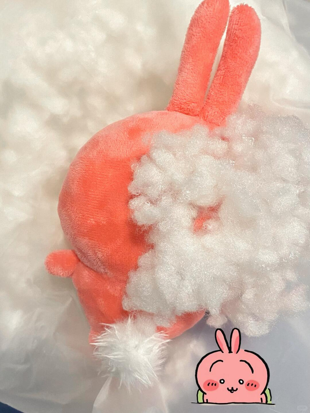 Pink Chiikawa-inspired full-body plush during stuffing, showing polyester fiberfill and long ears
