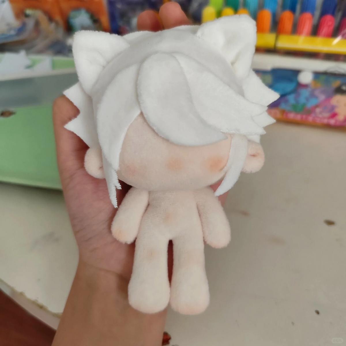 Blank plush doll base with sample white hair