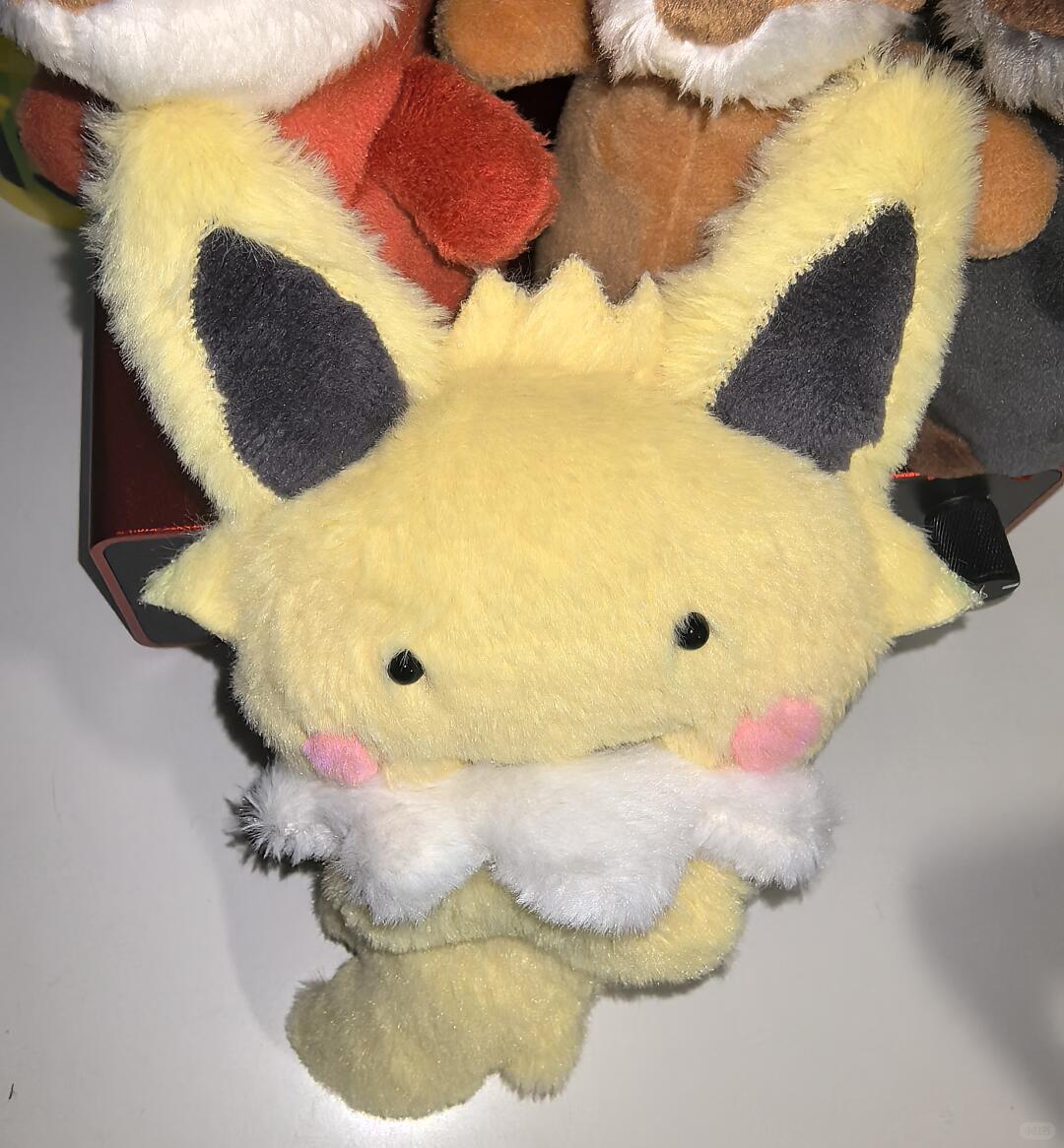 Handmade Eeveelution plush sewn from the pattern, showing a small yellow Jolteon-style plush with black ears, pink cheeks, and a white fluffy chest