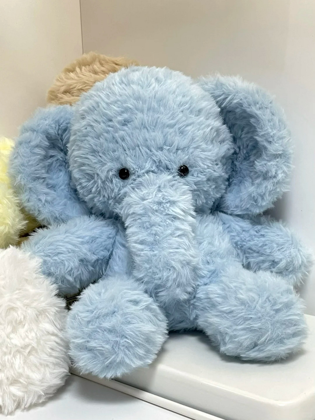Front view of a fluffy light blue handmade elephant plush