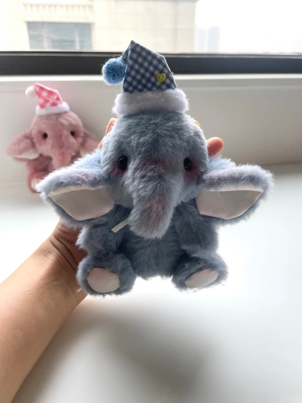 Handheld grey elephant soft toy with wide ears and a blue gingham nightcap