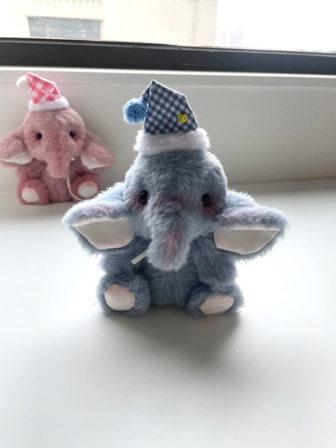 Fluffy grey handmade elephant plush wearing a blue gingham nightcap
